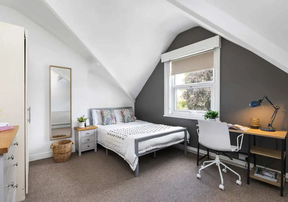 attic bedroom with dark grey feature wall